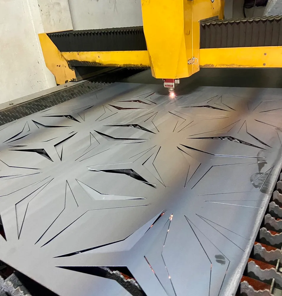 Laser cutting machine cutting a decorative pattern into sheet metal